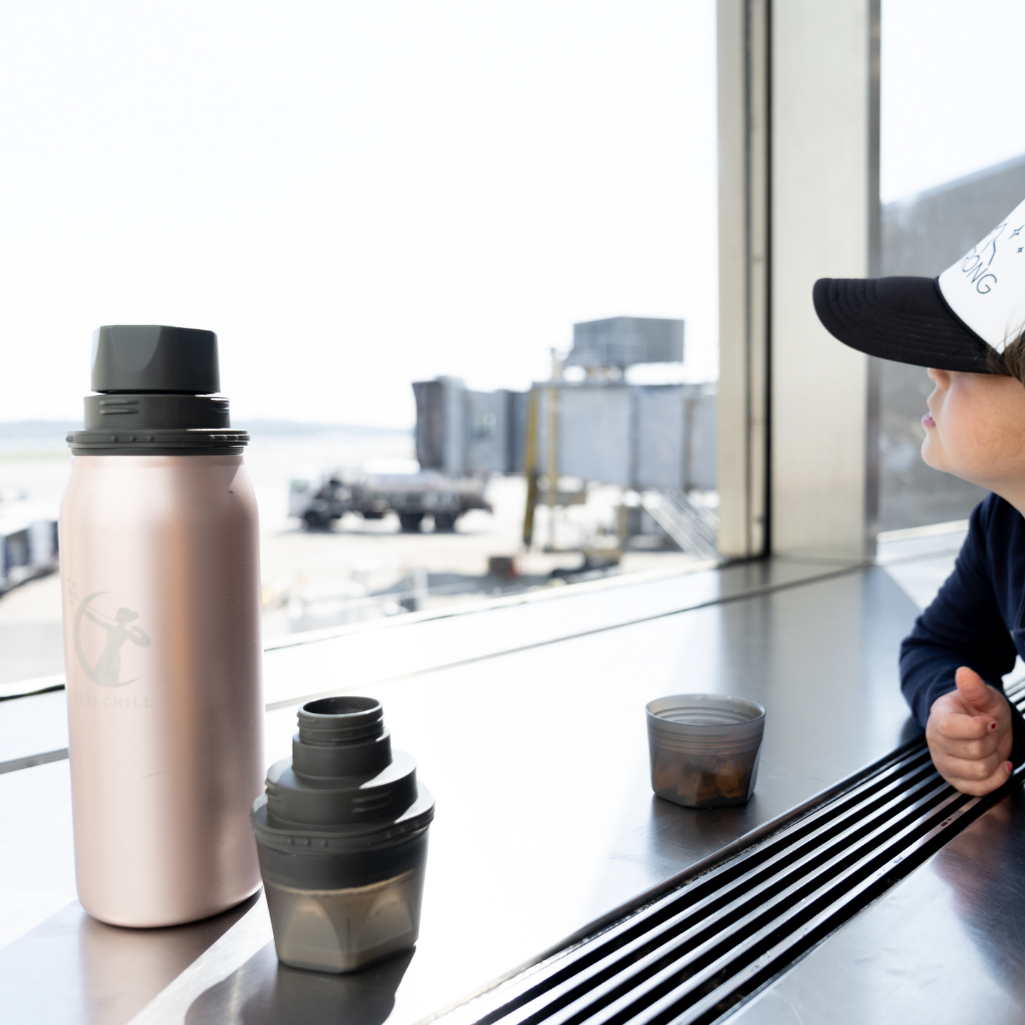 Pink Ceres Chill OG Chiller on a counter with accessories being used in an airport.