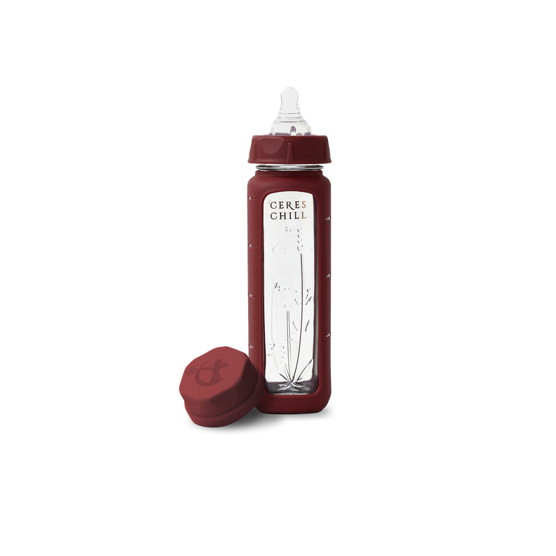 A red glass baby bottle with a white nipple and a label that reads 'Ceres Chill'. It comes with a matching red cap.