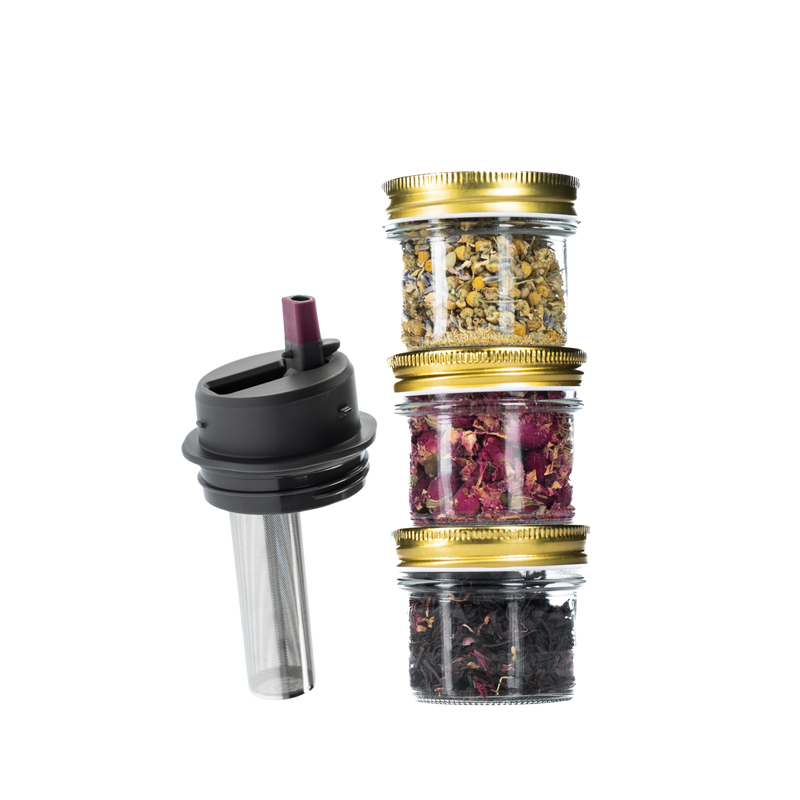 Stack of small jars with gold lids containing various teas, next to a black topped Ceres Chill Tea Infuser on a white background.