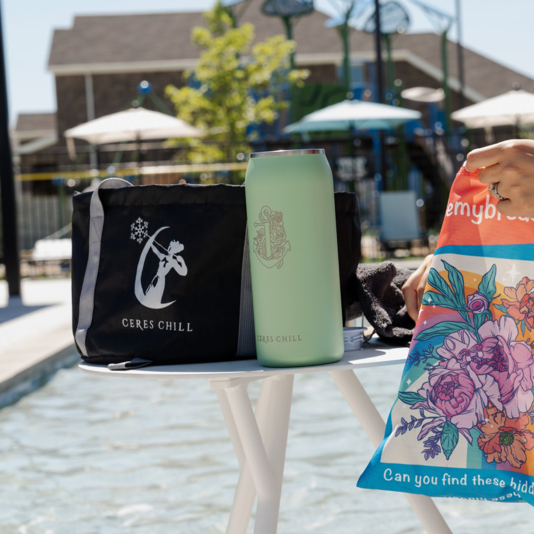 Ceres Chill Wash Basin bag with a personalized OG Chiller breast milk chiller storage bottle on a table and playground in the background. 