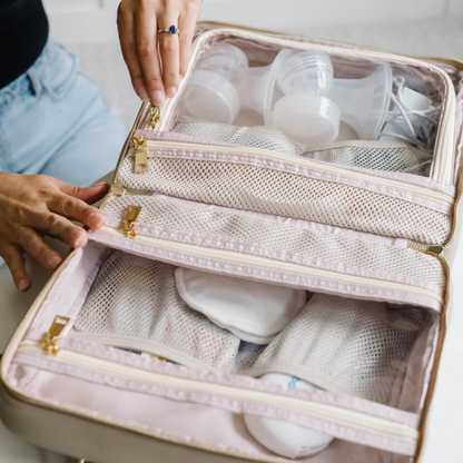 Person opening a beige travel organizer containing breast milk storage bags and bottles.