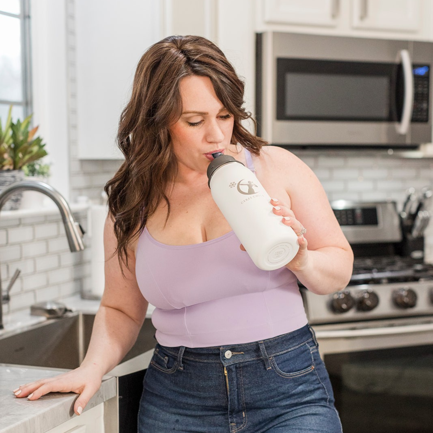 A woman drinking from her straw top tea infuser from Ceres Chill out of her OG Chiller. 